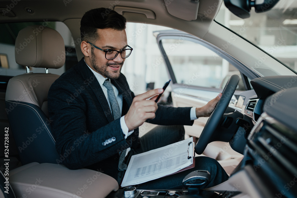 Car seller working in showroom and quality control checking of car details for the last time before buyer comes. Car seller working in showroom and quality control checking of car details for the last time before buyer comes.