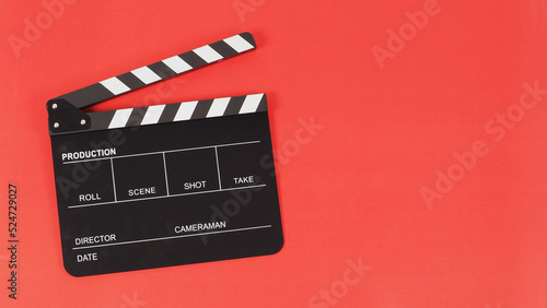 Fényképezés Black clapper board or movie slate on red background.