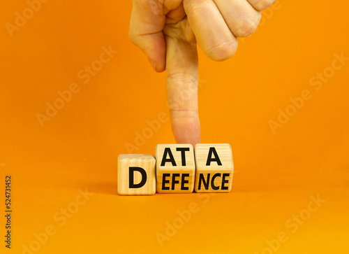 Data defence symbol. Concept words Data defence on wooden cubes. Beautiful orange table orange background. Businessman hand. Business and cyber crime concept. Copy space.