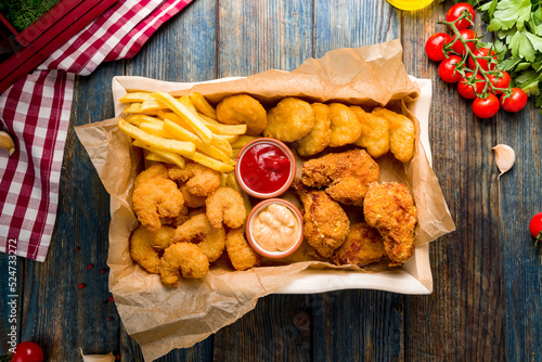 assorted beer snacks, chicken nuggets, french fries, shrimps temputa and chicken wings top view photo