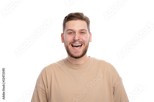 Portrait of handsome young man with happy smiling face standing over white background. Cheerful caucasian male with beard wearing casual beige sweater. © MYDAYcontent