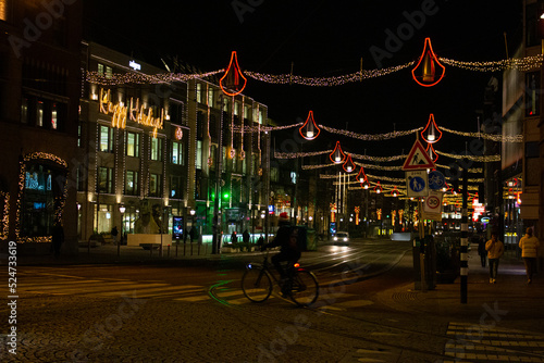 Amsterdam, Netherlands, December 21st 2021. A cyclist on a street of Amsterdam at night during partial lockdown before Christmas.
