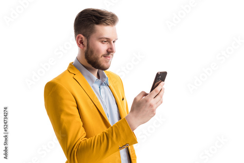 Focused successful male holding mobile phone and exchanging messages with coworkers. Smiling man using free internet connection on electronic gadget over white background. © MYDAYcontent