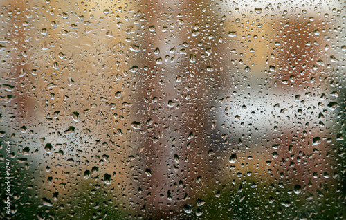 Water drops on the window glass. Rain falls on the surface of the window.