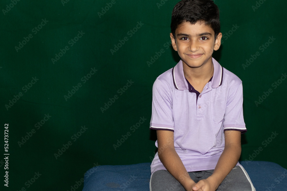 portrait of a smiling boy with green background