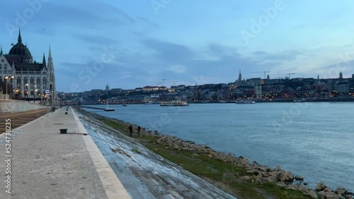 Danube River with a ship in the evening flies a lot of crows and pigeons in the distance bridge in the evening very beautiful all in blue 03.04.22 Danube Hungary. High quality 4k footage photo