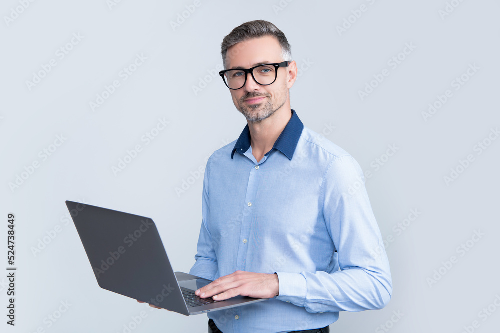 mature boss in eyeglasses working on computer on grey background mature boss in eyeglasses working on computer on grey background