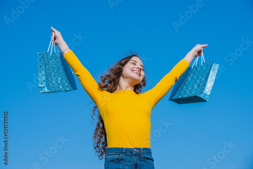 Tableau sur toile glad teen girl with shopping bags, blue yellow