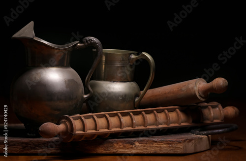 old sticks for kneading dough, metal jars and wooden board covered in dirt