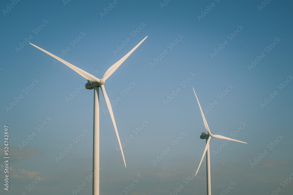Wind turbines generating electricity with blue sky - renewable energy conservation concept. Wind turbines farm Wind turbines generating electricity with blue sky - renewable energy conservation concept. Wind turbines farm
