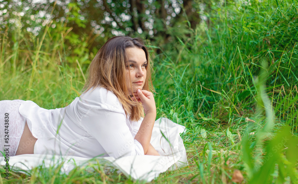 Portrait of a beautiful woman lying on the grass in a white shirt and openwork panties with a glass of wine Portrait of a beautiful woman lying on the grass in a white shirt and openwork panties with a glass of wine