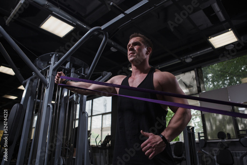 Low angle shot of a sportsman using resistance rubber band at the gym