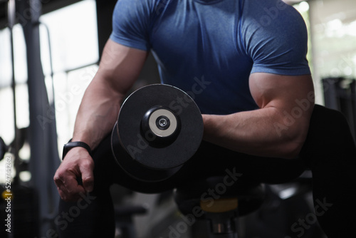 Unrecognizable muscular man doing bicep curls with dumbbell, cropped shot