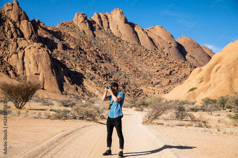 male traveler and photographer hiking in the desert of Namibia
