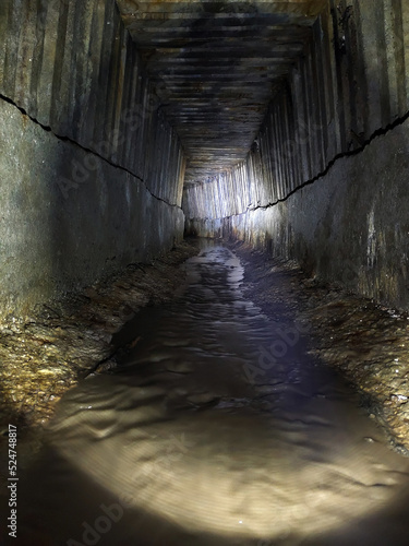 The tunnel of the underground sewage collector with ribbed walls going into perspective