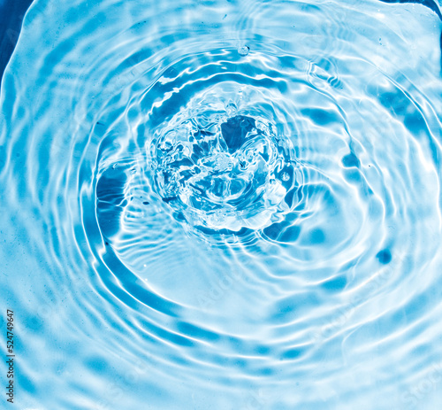 Flow of water is pouring on rippled water surface. Abstract background. Copy space for your design - stock photo