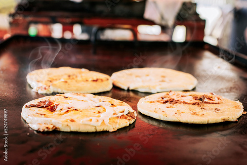 Quadro su tela Traditional Salvadoran pupusas with melted cheese on a grill, Traditional cheese pupusas on the grill