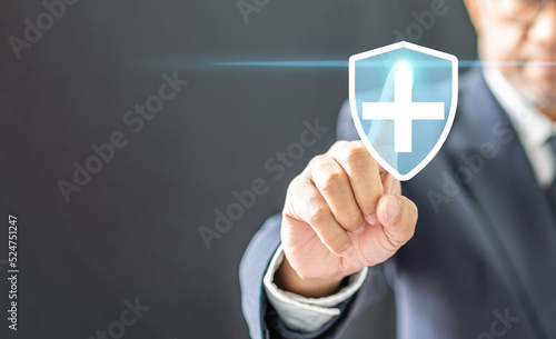 Business healthy and medical care insurance concept, professional Businessman finger pressing symbol cross shape with the shield icon and over gradient light blue, copy space on left, black background