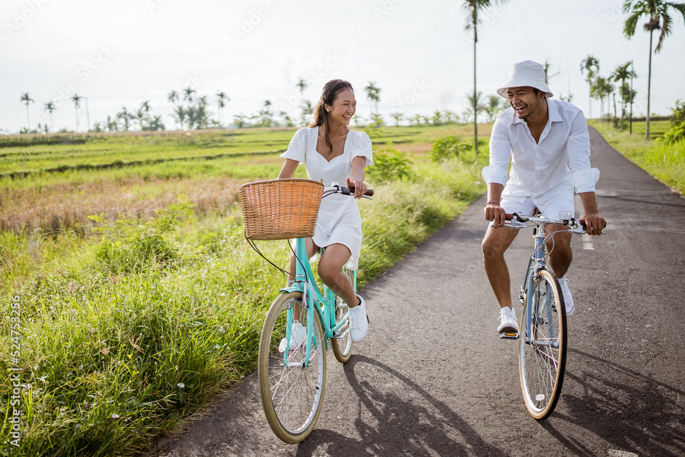 beautiful happy asian couple cycling on the road in countryside