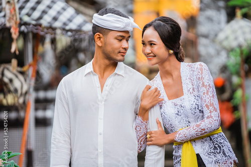 portrait of beautiful woman in balinese kebaya with her husband in typical bali village