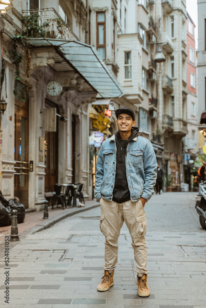 man with denim jacket smiling to camera full body portrait at the alley old town