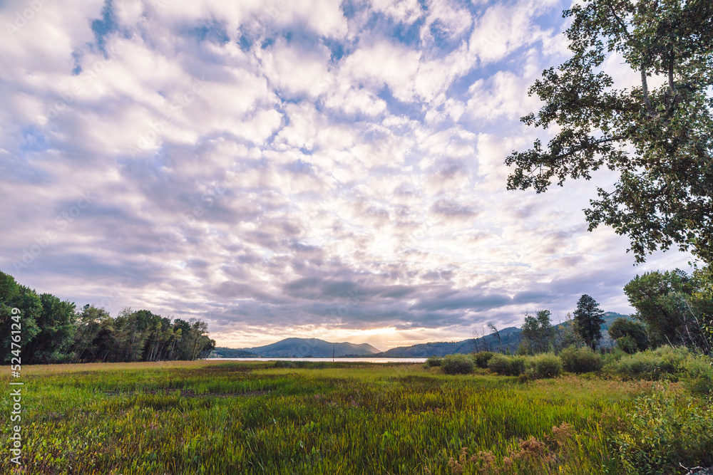 Fototapeta premium Whispy white clouds over a rural mountain landscape