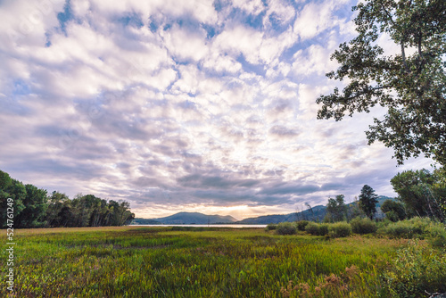 Whispy white clouds over a rural mountain landscape