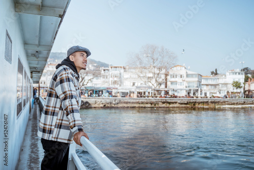 portrait of man leaning against the railing of the ferryboat while crossing the sea