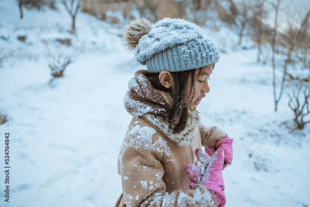 close up of a little girl in winter wearing coat full of snow close up of a little girl in winter wearing coat full of snow