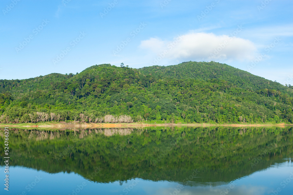 Beautiful reflection of clouds in water surface over lake or pond with Mountain tropical forest landscape nature background