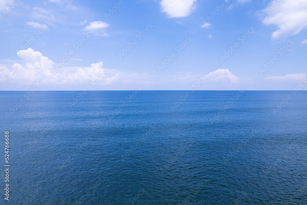 Obraz premium Aerial view of a blue sea surface water texture background and sun reflections Aerial flying drone view Waves water surface texture on sunny tropical ocean in Phuket island Thailand