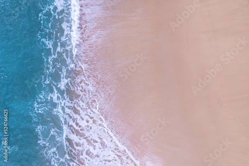Beach Sand Sea Shore and waves white foamy summer sunny day background.Amazing beach top down view overhead seaside nature background