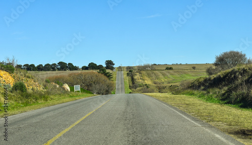 ruta en un camino monta  oso  con cortes en la linea de vision por las subidas y bajadas  con cielo azul y paisaje verde