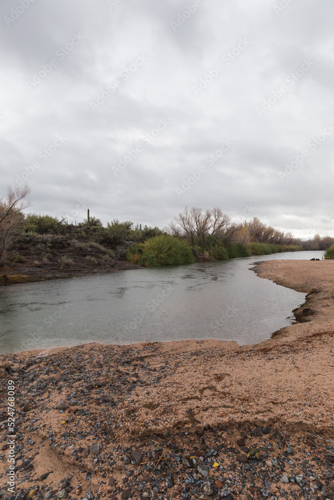 Foto de River of water under cloudy gray sky, Sonoran desert water in rainy season, Arizona