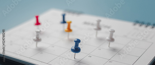 Embroidered red pins on a calendar event Planner calendar,clock to set timetable organize schedule,planning for business meeting or travel planning concept.
