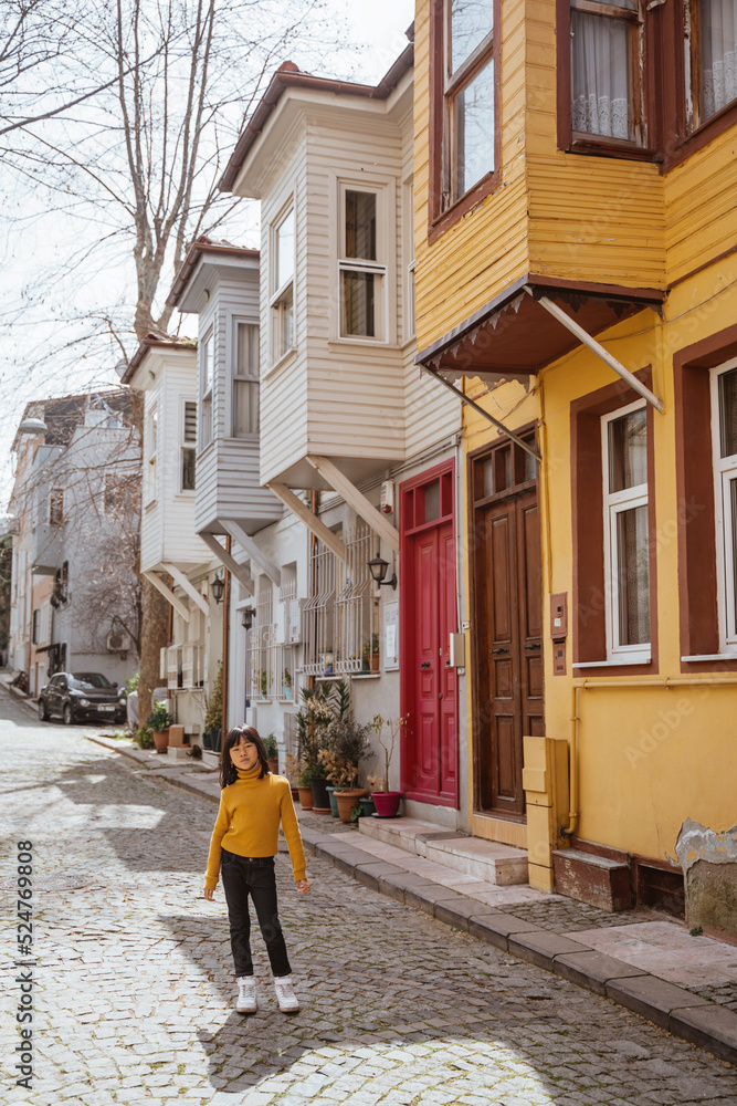 happy young girl exploring around kuzguncuk area with colorful building