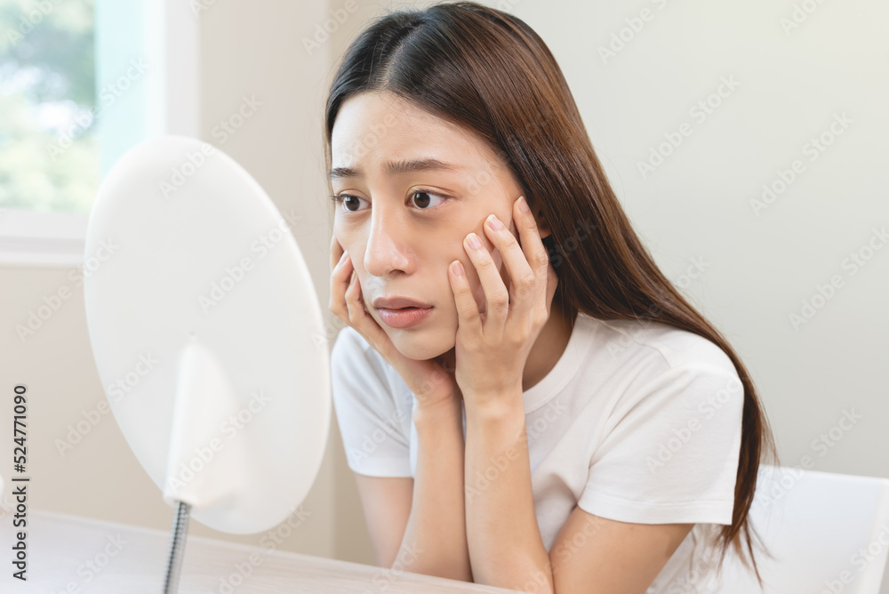Sleepless Asian woman looking her face in the mirror and worry about dark circles under eyes Sleepless Asian woman looking her face in the mirror and worry about dark circles under eyes