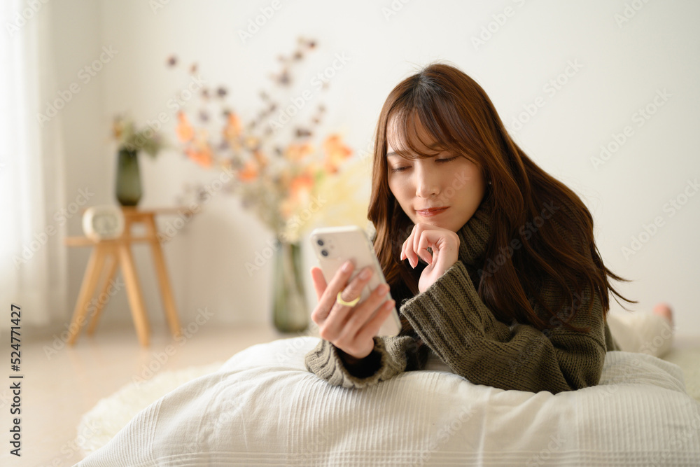 スマホを持つ日本人女性 コピースペースあり 秋冬ニット 考える スマホを持つ日本人女性 コピースペースあり 秋冬ニット 考える