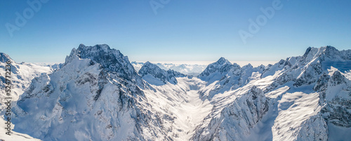 Mountain peaks covered in snow under a clear blue sky 