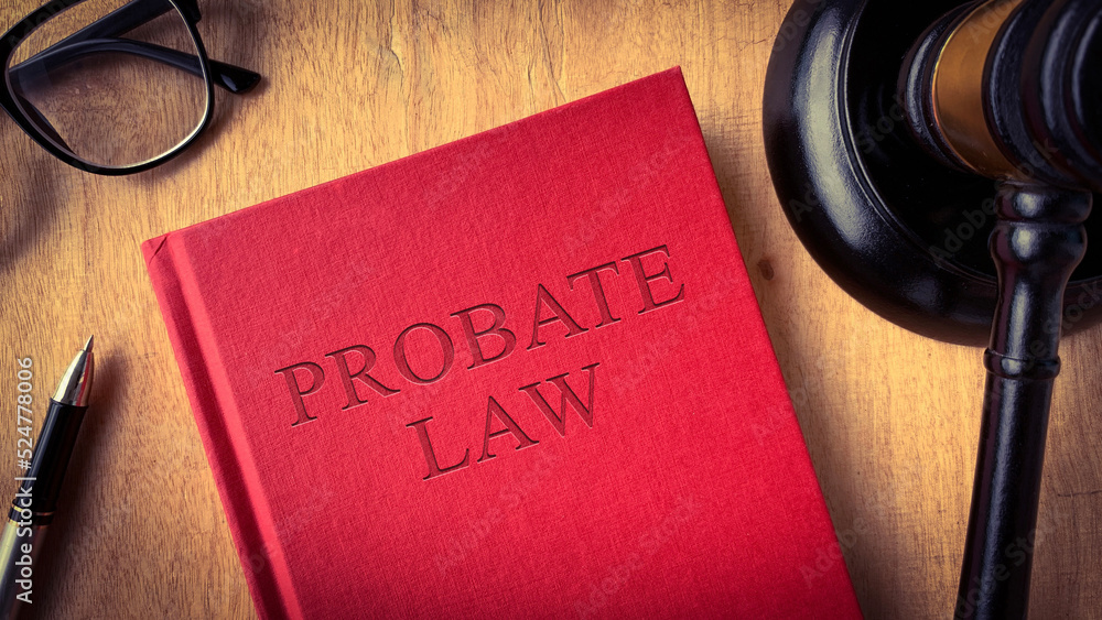 Probate law book on wooden table surrounded with gavel, glasses and pen. Law concept Probate law book on wooden table surrounded with gavel, glasses and pen. Law concept