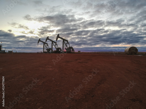 Oil field with cloudy sky and baren soil photo
