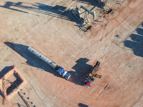 View of semi trucks and oil derrick from above