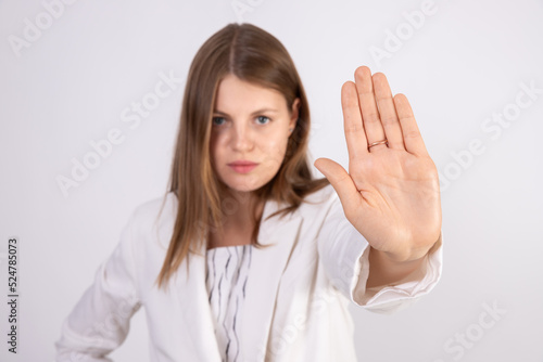 Wallpaper Mural Close-up of young businesswoman making stop gesture. Caucasian woman wearing white jacket showing rejection sign over white background. Rejection or denial concept Torontodigital.ca