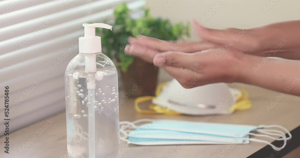 Close up taking disinfection alcohol gel on hands for hand hygiene on and corona virus pandemic protection . New normal cleaning and disinfecting hands for Covid-19 prevention concept Close up taking disinfection alcohol gel on hands for hand hygiene on and corona virus pandemic protection . New normal cleaning and disinfecting hands for Covid-19 prevention concept