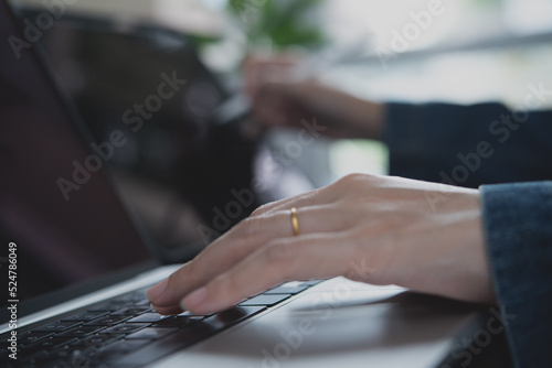 Close up of business woman hands typing on laptop computer and using digital tablet pc, online working from home office