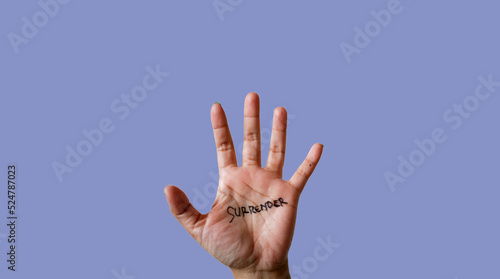 Word surrender written on hand isolated on blue background