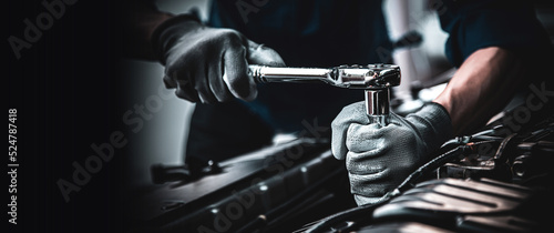Car care maintenance and servicing, Close-up hand technician auto mechanic using the wrench to repairing change spare part car engine problem and car insurance service support. photo