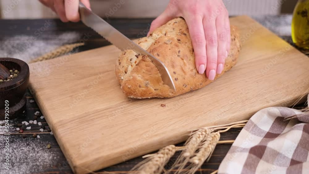 woman slicing bread on wooden cutting board woman slicing bread on wooden cutting board