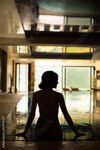 Rear view of young woman relaxing on the poolside