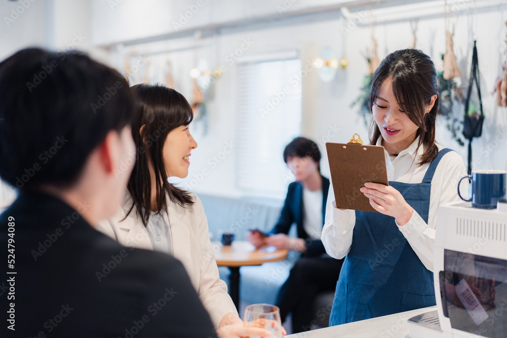 カフェで注文を取る若いスタッフ カフェで注文を取る若いスタッフ